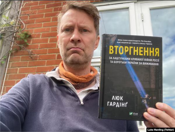 Люк Гардінг тримає свою книжку "Вторгнення" у перекладі українською