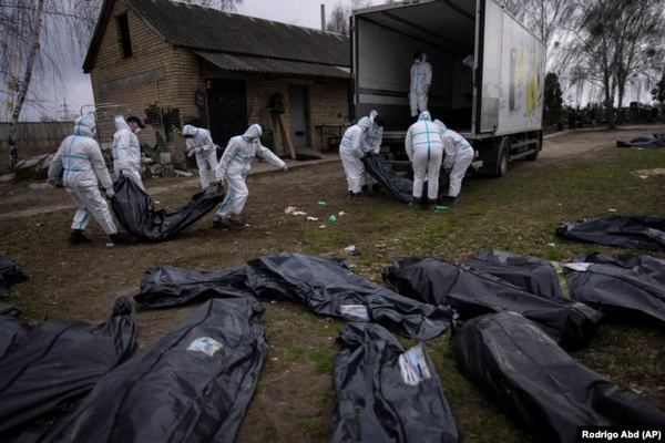 Ліворуч вниз головою в червоному капюшоні лежить тіло Павла Холоденка, а праворуч ‒ Віктора Балая. Фото надані жителями села Здвижівка, які відкопали захоронення. Київщина. Квітень 2022 року