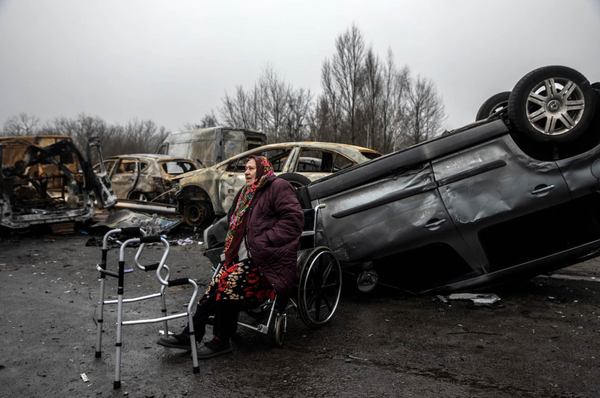 78-річна Віра з Бучі чекає, поки хтось допоможе їй переїхати під мостом в Ірпіні. Квітень 2022. Фото: The Washington Post